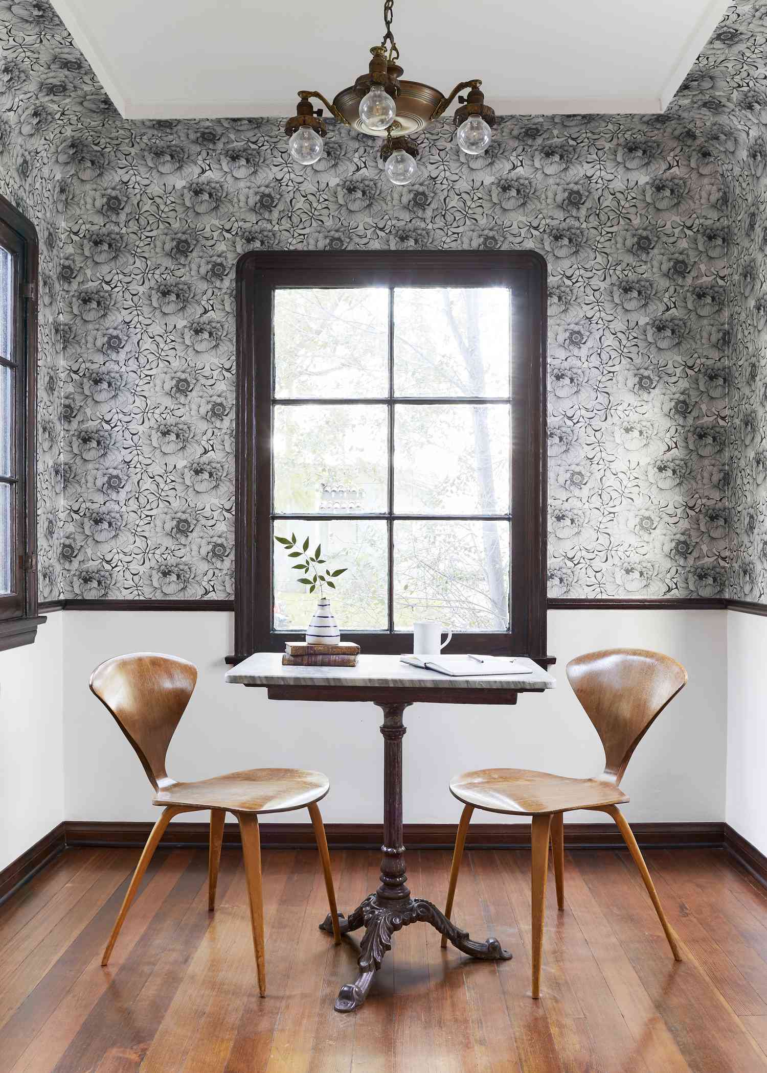 Papier peint floral dans une salle à manger avec des chaises en bois