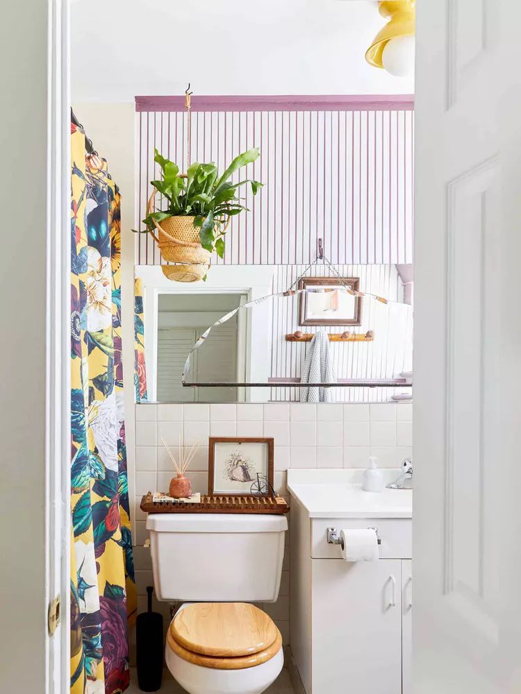 Une salle de bain lumineuse et colorée avec un rideau de douche imprimé.