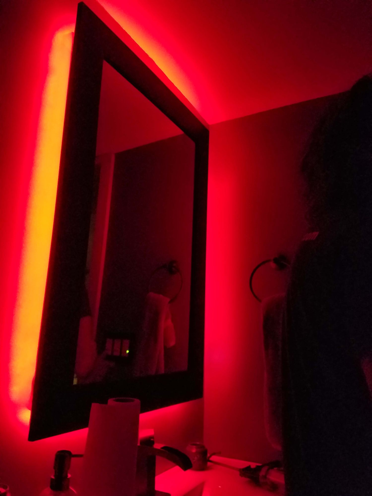 Un miroir rouge rétroéclairé dans une salle de bain