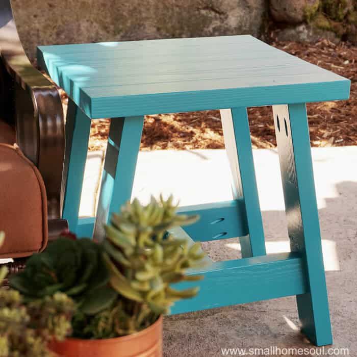 Une table d'appoint bleue posée sur un porche