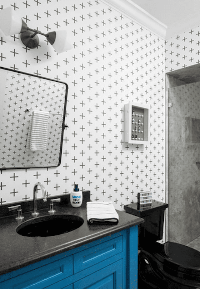 Salle de bain avec papier peint noir et blanc et meuble-lavabo bleu
