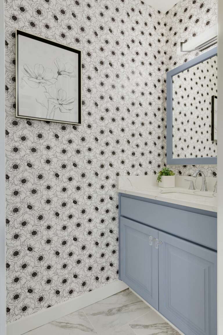 Salle de bain avec meuble-lavabo et miroir bleus et papier peint noir et blanc