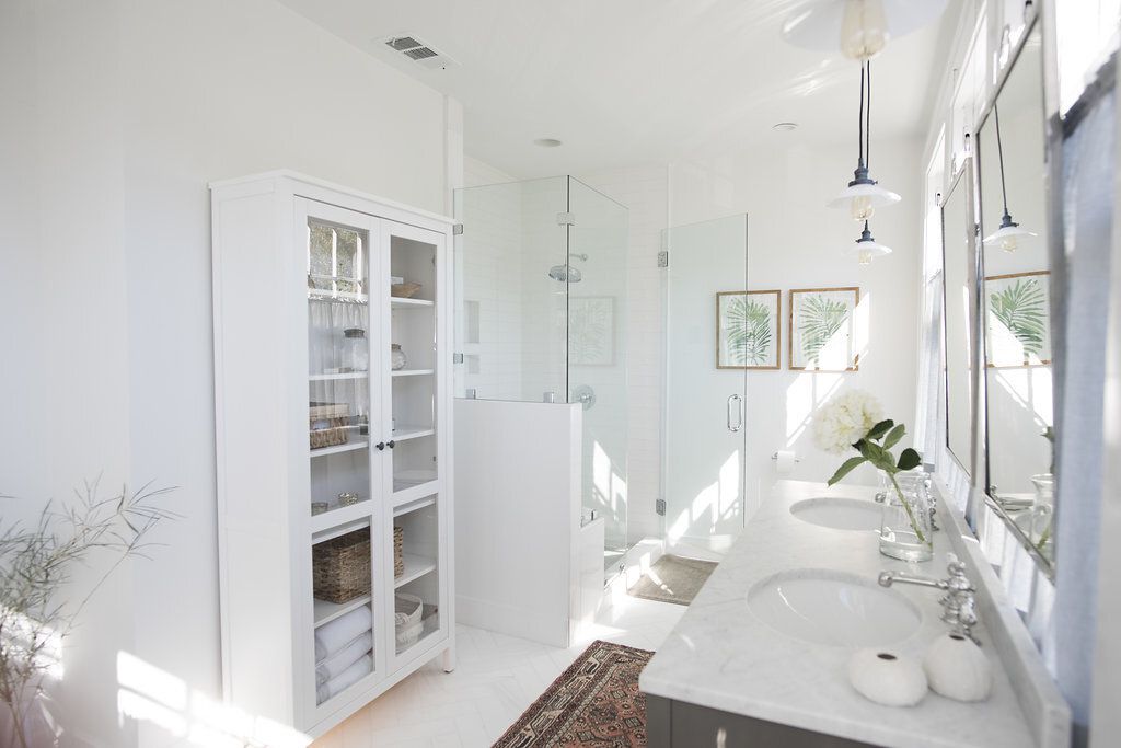 Une armoire blanche dans une grande salle de bain