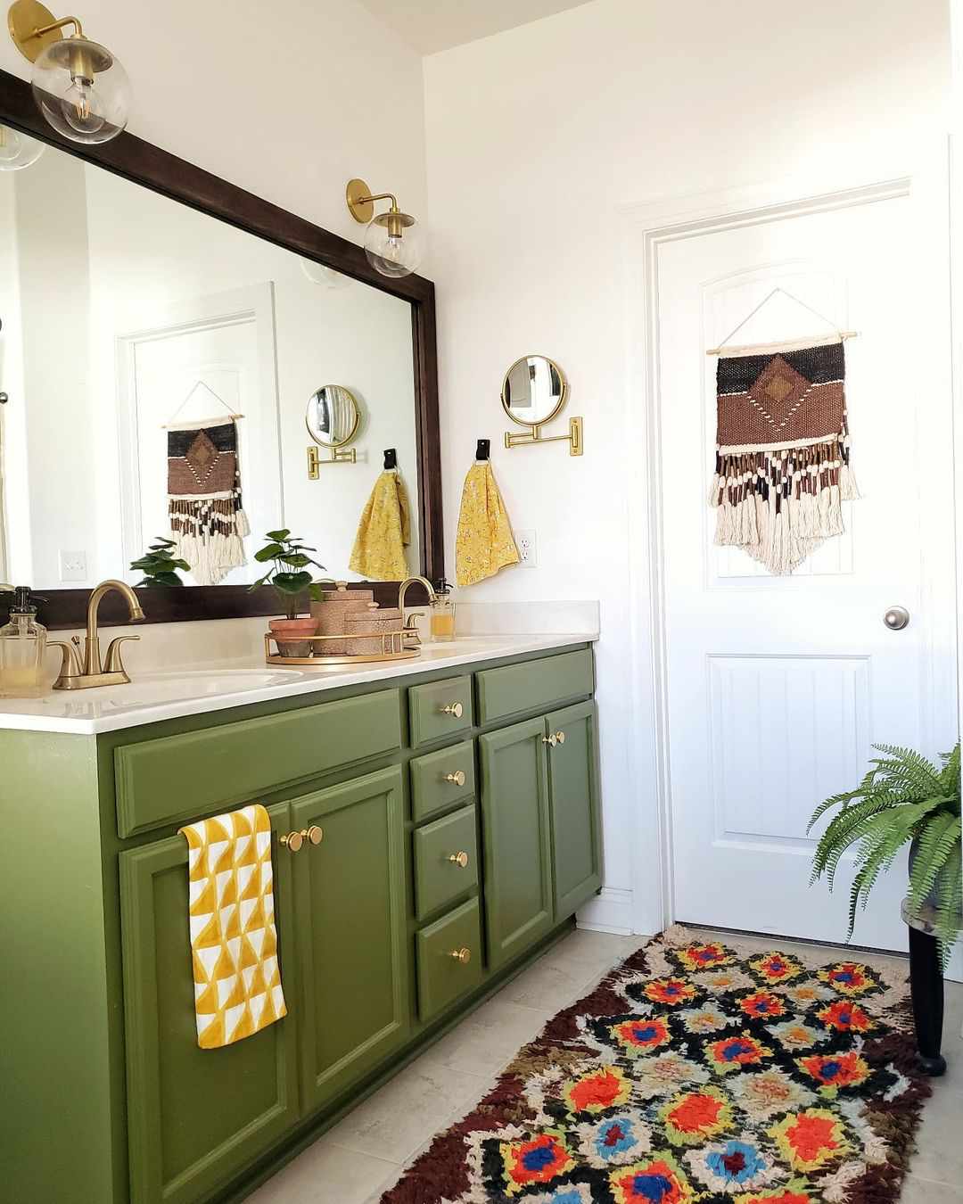 Une salle de bains avec un meuble-lavabo vert et des accessoires colorés