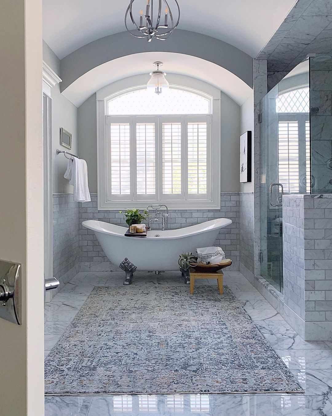 Un grand tapis dans une salle de bain luxueuse avec une baignoire autoportante.