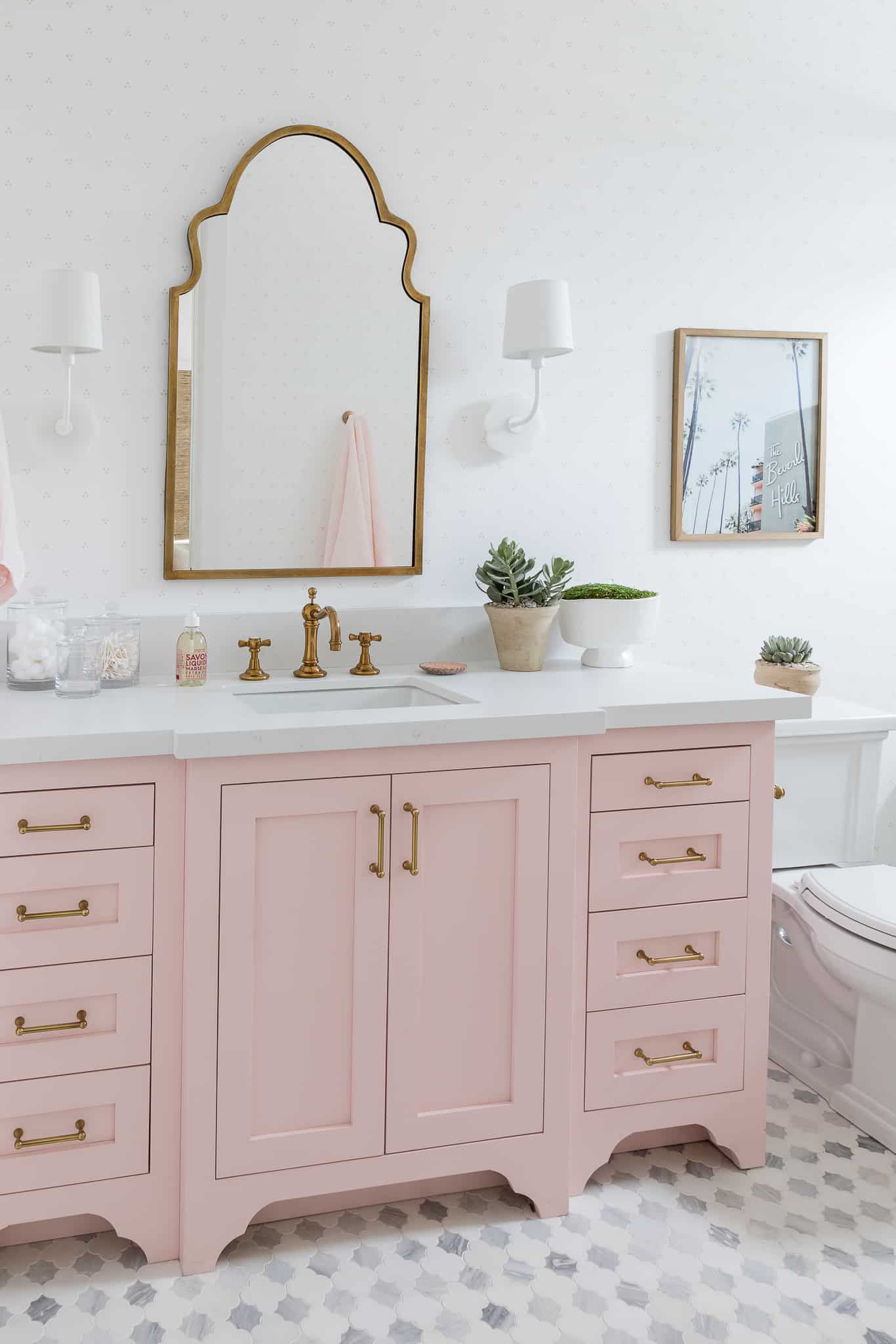 Miroir orné et meuble de salle de bain rose