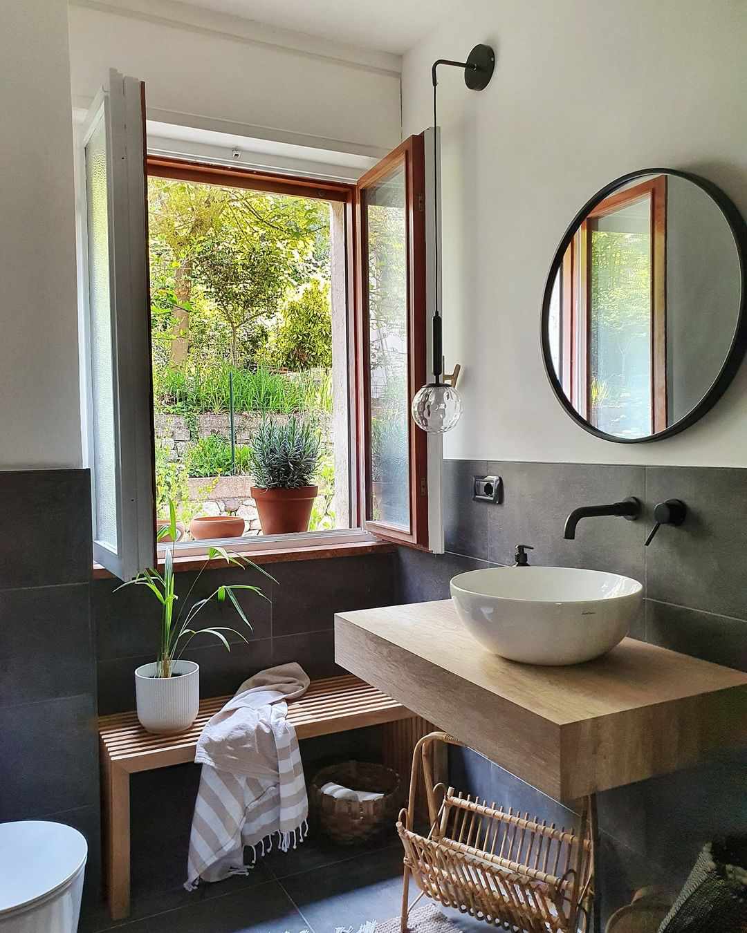 Un meuble-lavabo flottant en bois et un banc en bois dans une salle de bain