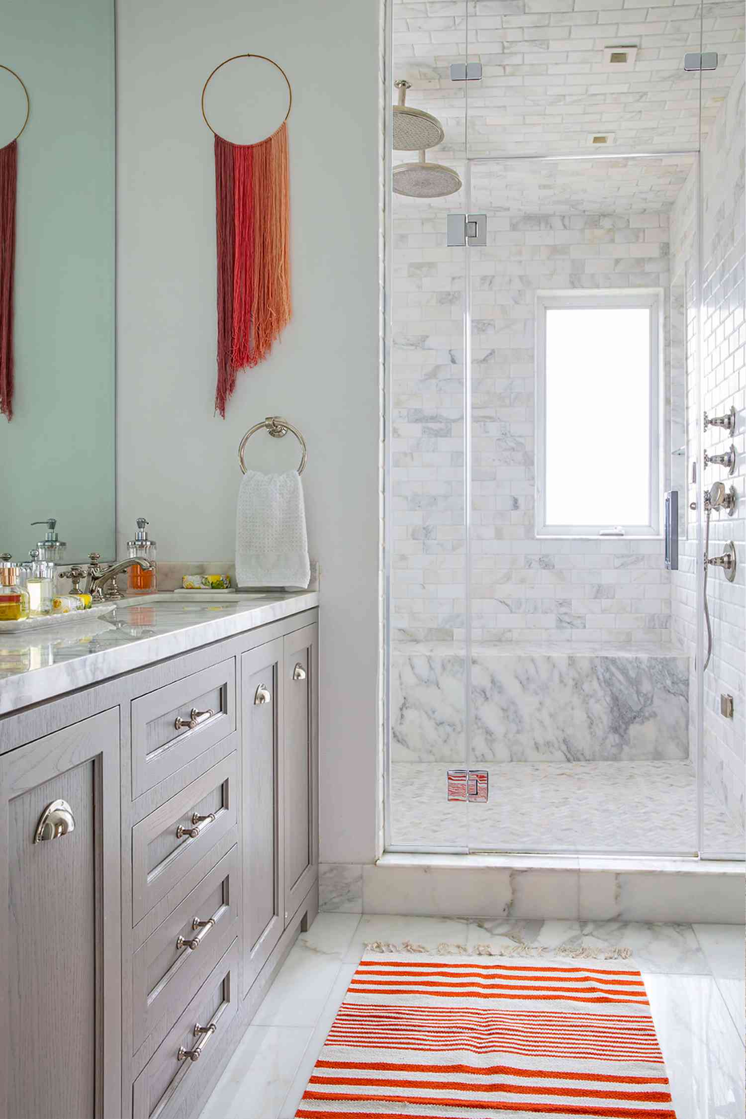 Une salle de bain neutre avec des fils d'art colorés suspendus.