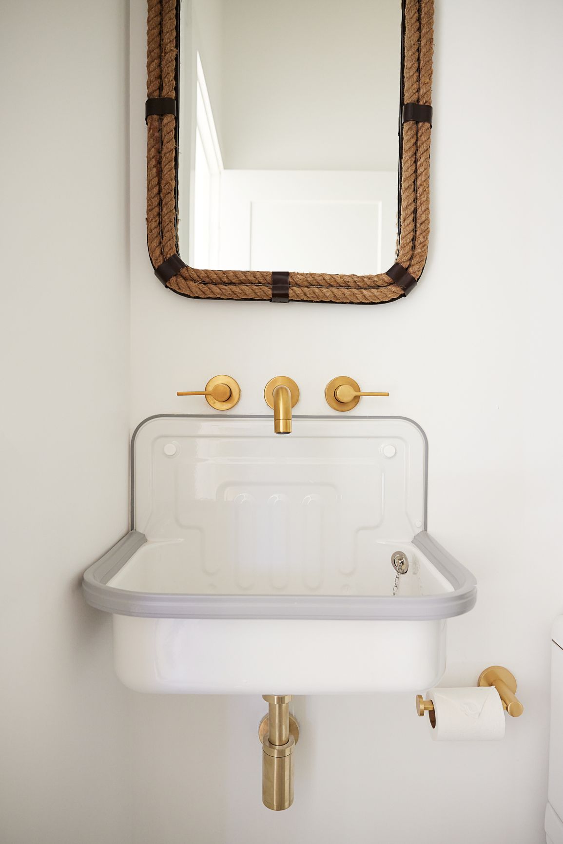Évier de ferme dans une salle de bain avec miroir nautique