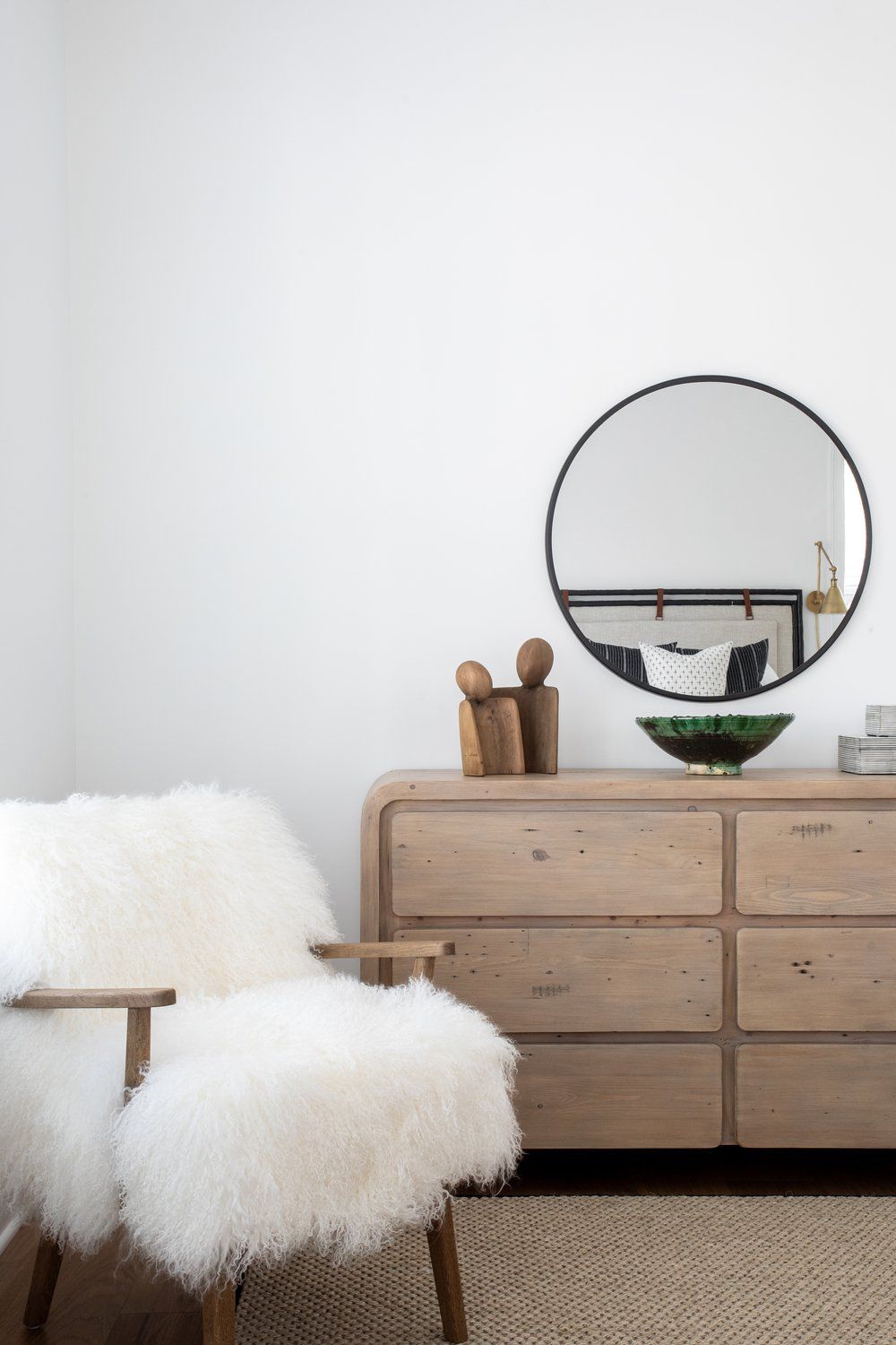 miroir rond noir minimaliste au-dessus d'une commode