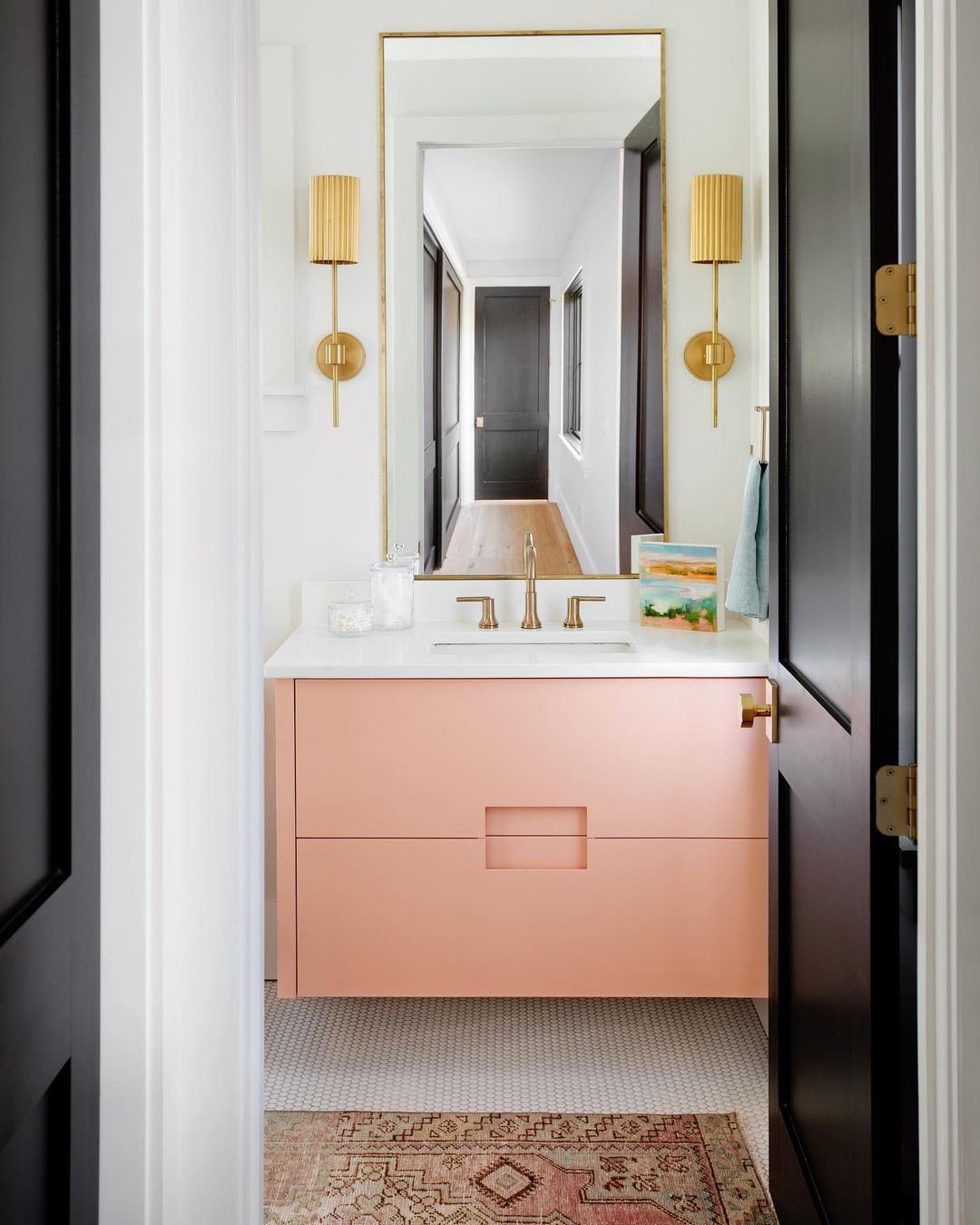 Une petite salle de bain avec un charmant meuble flottant rose