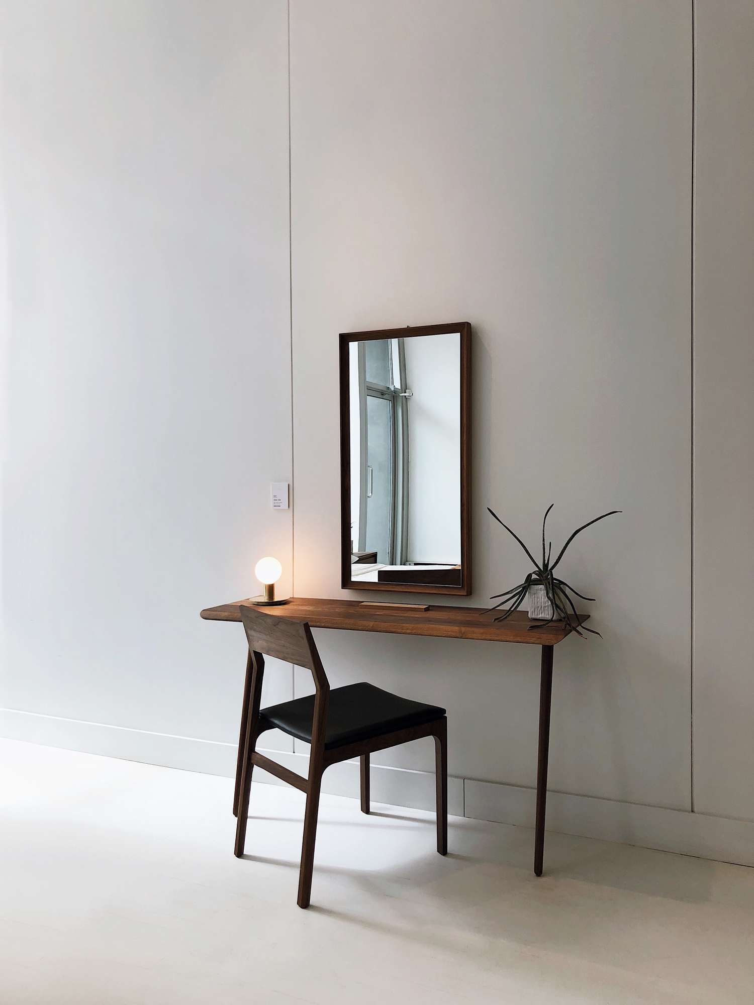 miroir rectangulaire encadré en bois au-dessus d'un bureau et d'une chaise